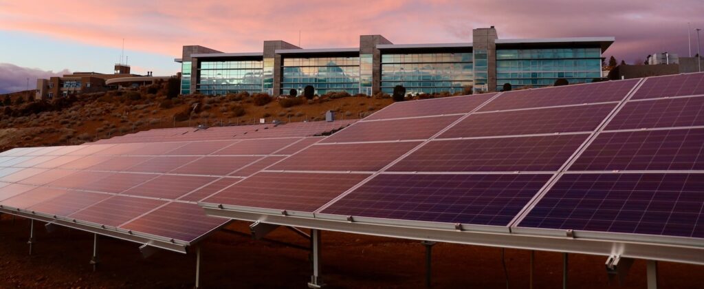 Painéis solares sob pôr do Sol rosado para 4 excelentes benefícios da energia solar para empresas