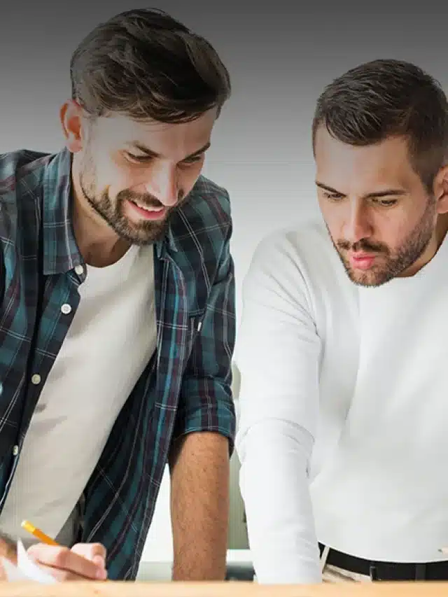 Três homens jovens debruçado sobre a mesa como se tivessem discutindo algum projeto para exemplificar artigo sobre quem pode migrar para o mercado livre de energia? Entenda!