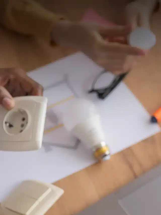Um par de mãos segurando um soquete, na mesa abaixo uma lampada LED para artigos sobre Saiba o que é sustentabilidade empresarial