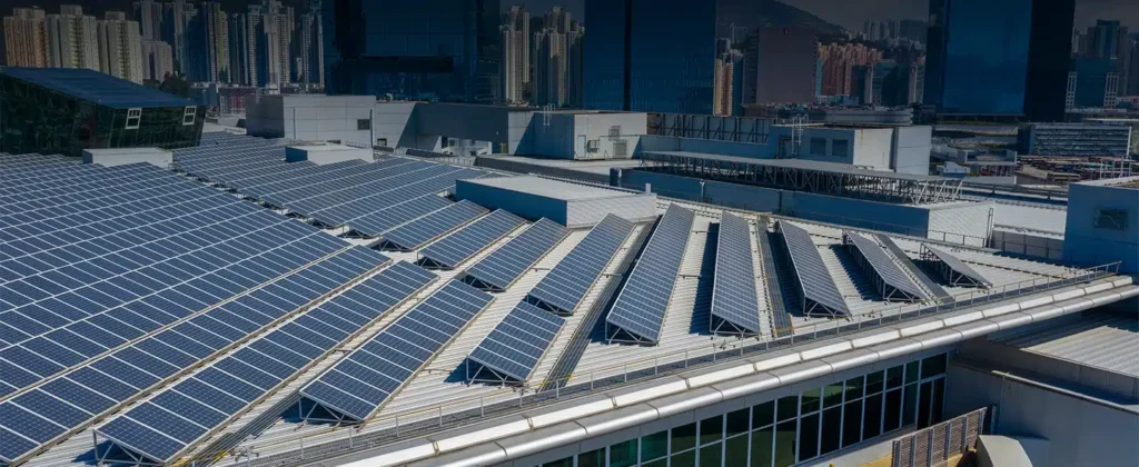 Telhado de prédio com painéis solares e ao fundo vários prédios para artigo de Como ter energia solar sem precisar comprar painéis solares