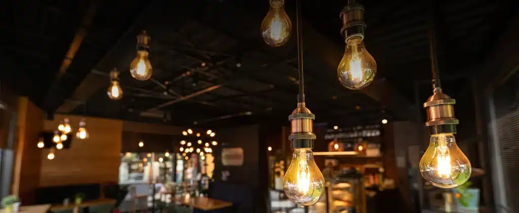 Teto com lâmpadas amarelas para iluminar restaurante para artigo sobre Como usar aparelho para economizar energia