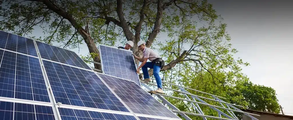 Homens instalando painéis solares sobre Como contratar energia solar compartilhada para sua empresa?
