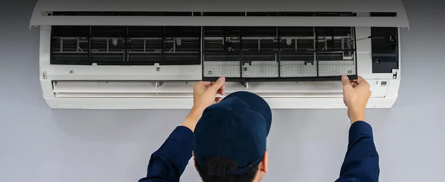 Homem consertando ar-condicionado, artigo sobre Vale a pena usar energia solar para ar-condicionado?