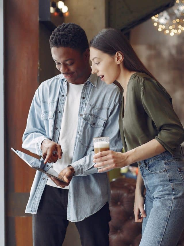 Internationals people standing in a cafe with tablet and coffee