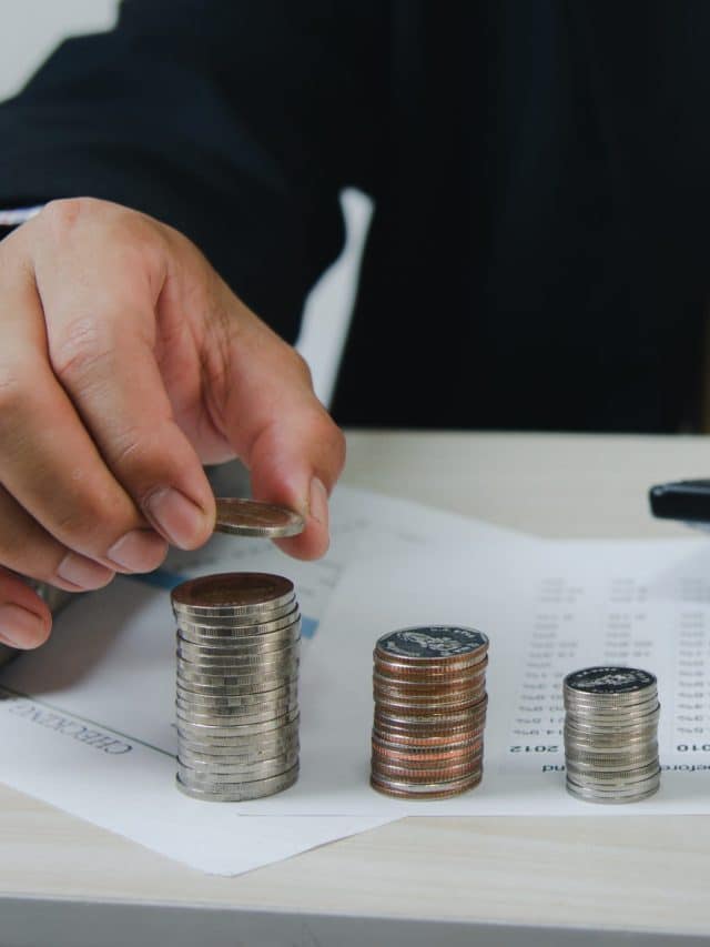 Male hands holding coins and paper documents calculator.Business