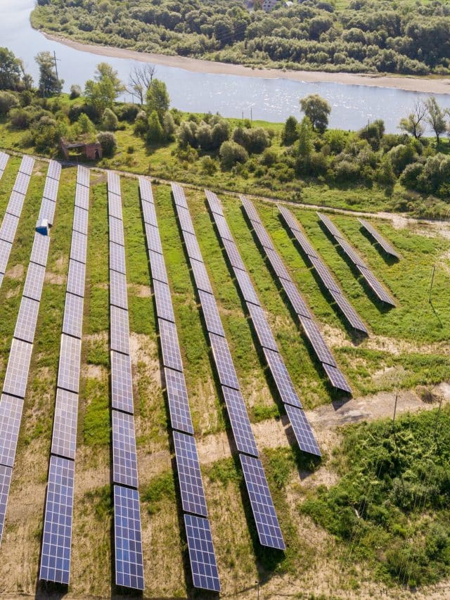 Aerial view of solar power plant on green field. Electric farm w