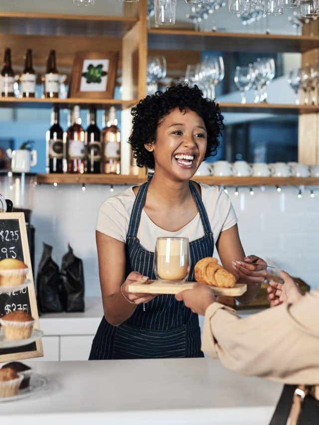 happy-woman-barista-serving-customer-cafe-service-payment-order-counter-coffee-shop-african-person-waitress-employee-small-business-restaurant-helping-client-checkout