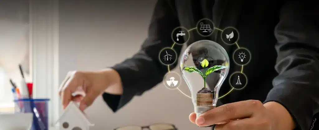 Mão segurando lâmpada com símbolos de sustentabilidade para O que é governança ambiental?