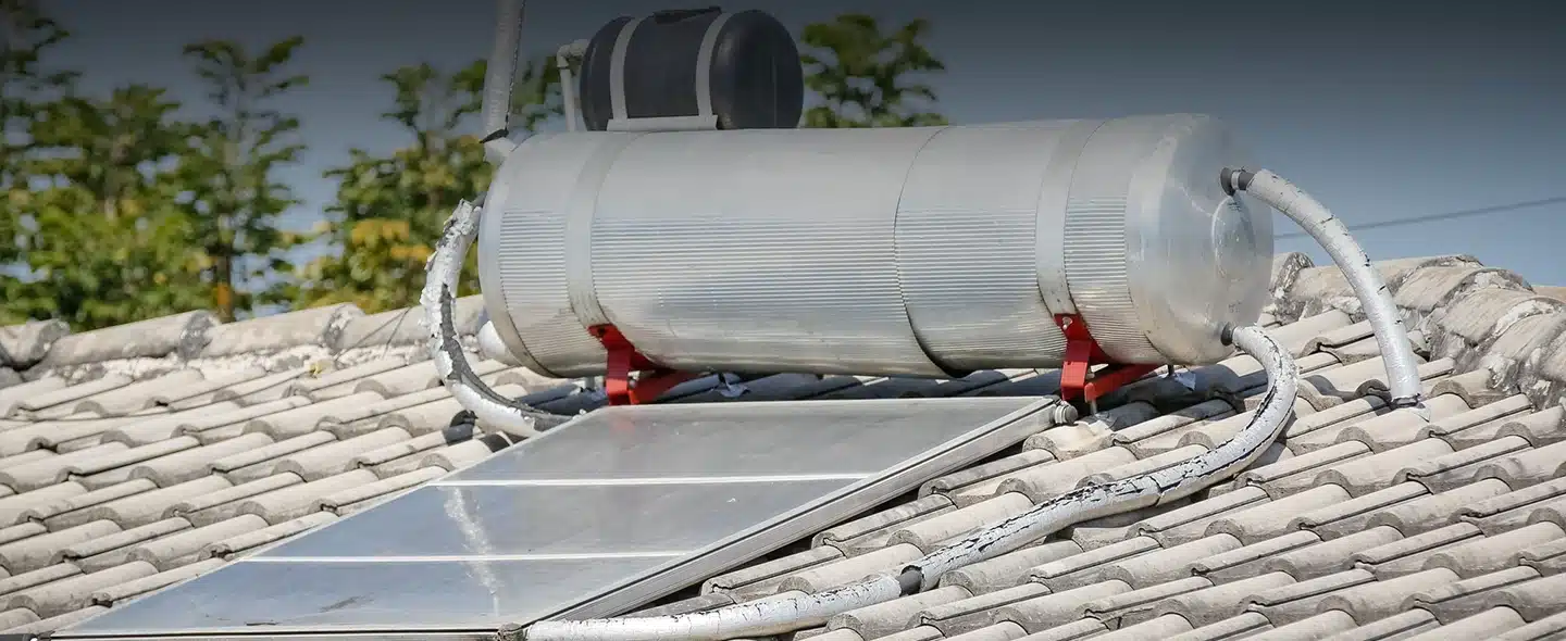 Cilindro metálico e painel solar para Como funciona a energia solar térmica e onde pode ser usada?