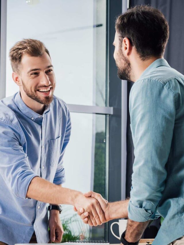 handsome-smiling-businessmen-shaking-hands-meeting-office (1)