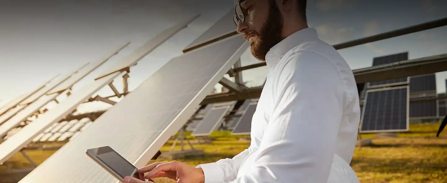 Técnico ao lado de painel solar para Como uma parceria solar ajuda cliente de baixa tensão?