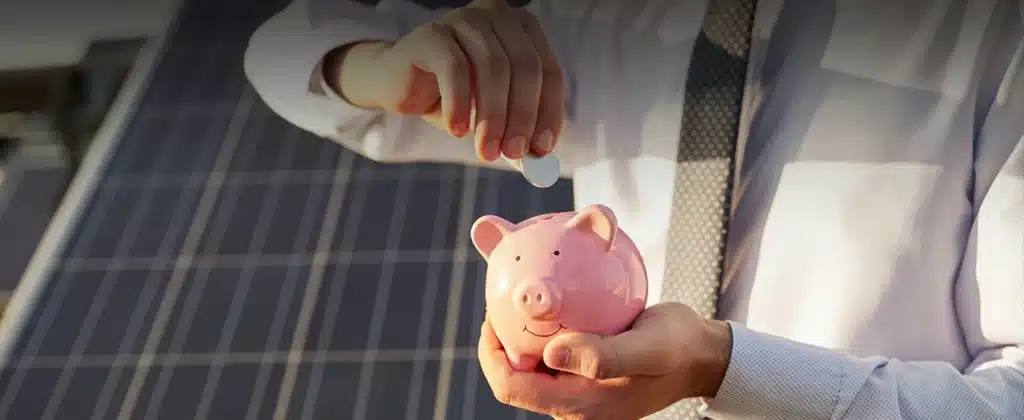 Homem colocando moeda em cofre de porquinho para Descubra se créditos de energia solar é legal