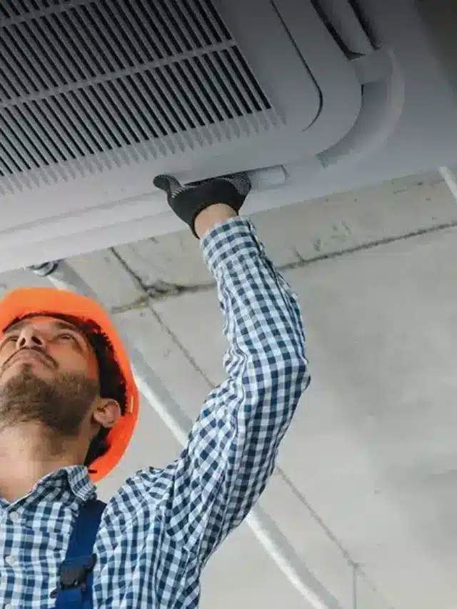 Técnico avaliando ar-condicionado de teto Quanto gasta um ar-condicionado com energia solar?