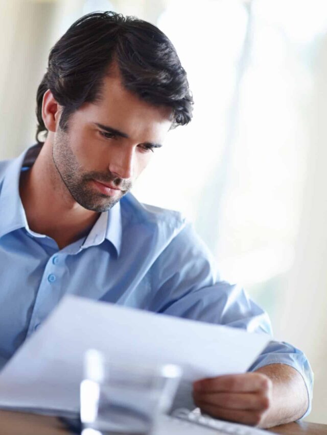 A handsome young businessman working on his laptop at his desk.
