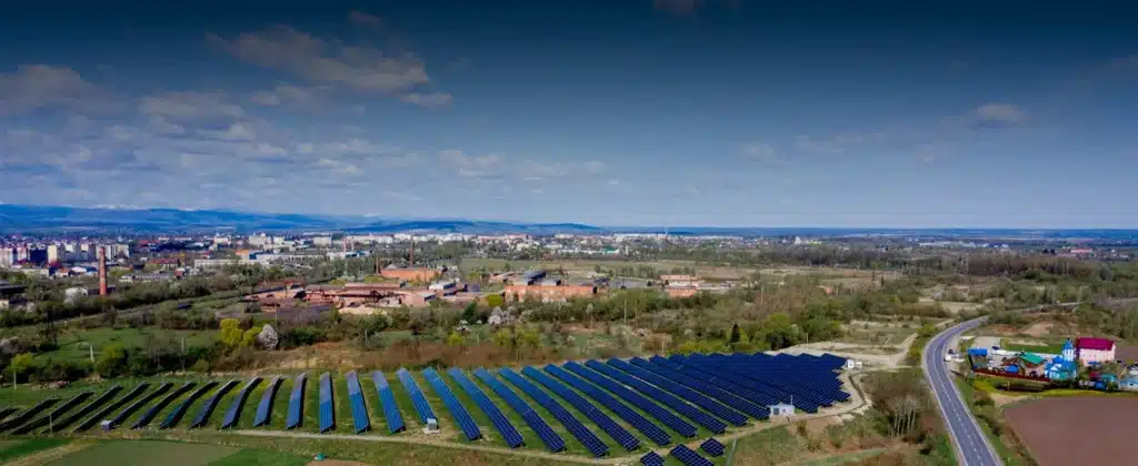Painéis solares, uma cidade e céu azul para Qual o valor arrendamento de terra para energia solar?