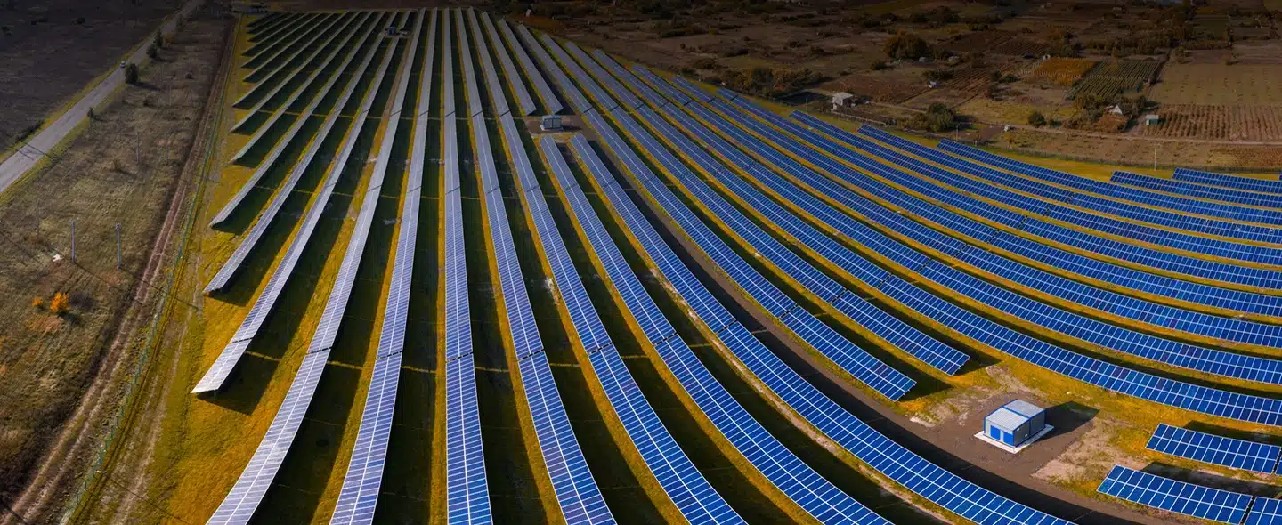 Fileira de paineis visto sobre lente angular para Investimento em usina solar: vale a pena