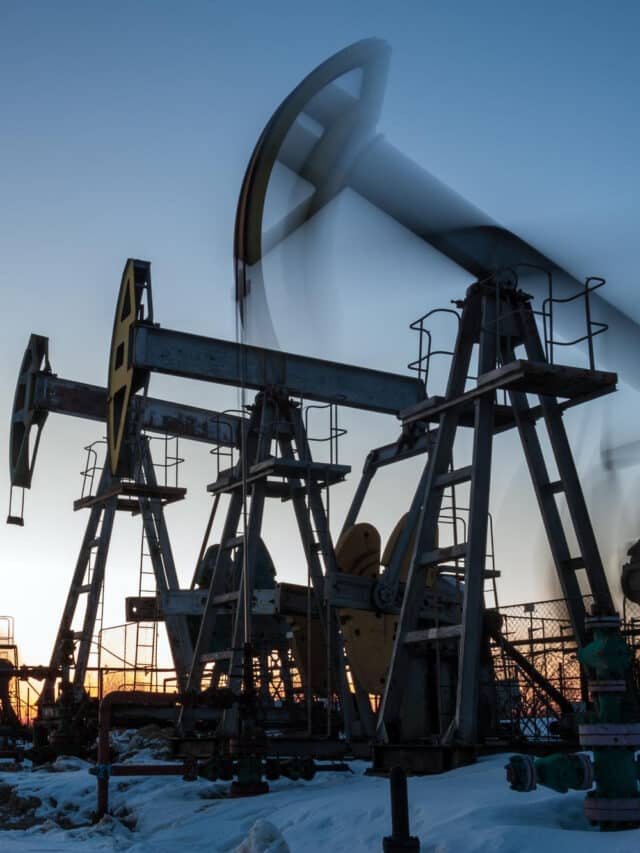 grupo-de-macacos-de-bomba-de-oleo-e-cabeca-de-poco-com-armadura-de-valvula-durante-o-por-do-sol-no-campo-petrolifero-conceito-de-petroleo-e-gas