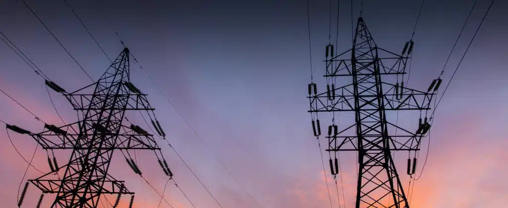 Silhuetas de linhas de energia em um pôr do sol para ilustrar o que é energia injetada