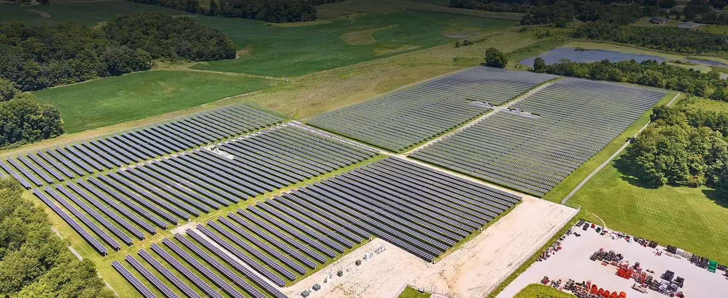 Imagem da vista do alto de uma fazenda solar em um campo para ilustrar parques fotovoltaicos