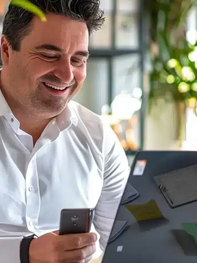 Um homem está sentado feliz com a em uma mesa com a energia por assinatura contratada