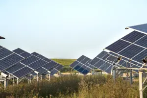 Visão aérea de painéis solares de um micro usina solar no meio de um campo verde