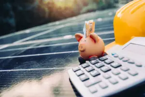 Cofrinho com dinheiro e calculadora sobre painel solar, representando economia na conta de luz com energia por assinatura, sem instalação de equipamentos.