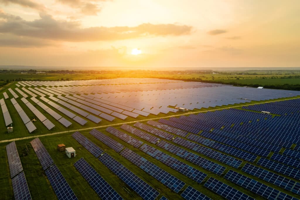 Vista aérea de uma usina solar com painéis fotovoltaicos, representando o modelo de energia por assinatura e sua aplicação em larga escala.