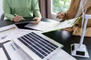Dois profissionais analisando os custos envolvidos nos planos de energia por assinatura.