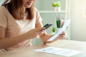 Consumidora avalia sua conta de energia elétrica, ilustrando o impacto da economia gerada com energia por assinatura.