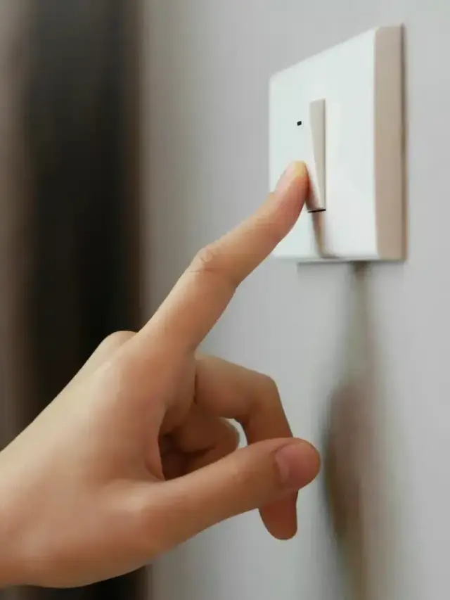 Pessoa desligando o interruptor, representando redução de consumo e dúvidas sobre o funcionamento da energia por assinatura.