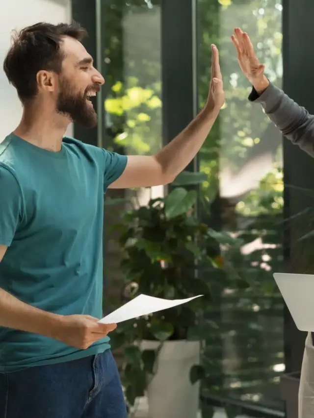 Dois profissionais comemorando parceria de sucesso, simbolizando estratégias colaborativas para captação de consumidores em energia solar.