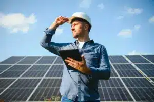 engenheiro com tablet avaliando placas solares em consultoria em energia solar