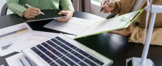 Dois profissionais analisando os custos envolvidos nos planos de energia por assinatura.