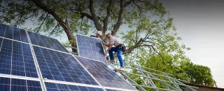 Homens instalando painéis solares sobre Como contratar energia solar compartilhada para sua empresa?