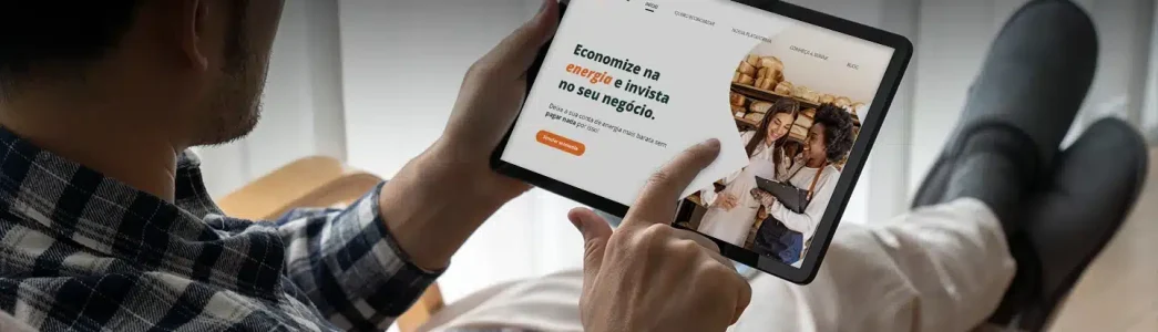 Homem segurando tablet para artigo O que não é permitido no ambiente de contratação livre