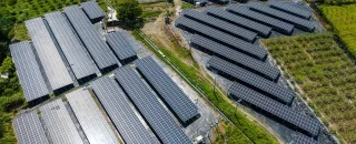 Visão aérea de painéis solares de um micro usina solar no meio de um campo verde