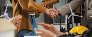 Engenheiros apertam as mãos enquanto trabalham para o trabalho em equipe no mercado livre de energia