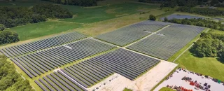 Imagem da vista do alto de uma fazenda solar em um campo para ilustrar parques fotovoltaicos