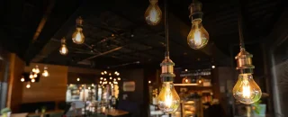 Teto com lâmpadas amarelas para iluminar restaurante para artigo sobre Como usar aparelho para economizar energia