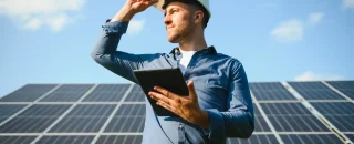 engenheiro com tablet avaliando placas solares em consultoria em energia solar