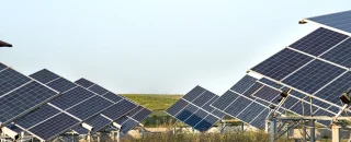 Visão aérea de painéis solares de um micro usina solar no meio de um campo verde